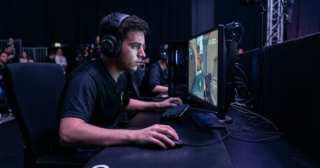Professional Valorant player using a gaming mouse and monitor setup during a competitive esports match