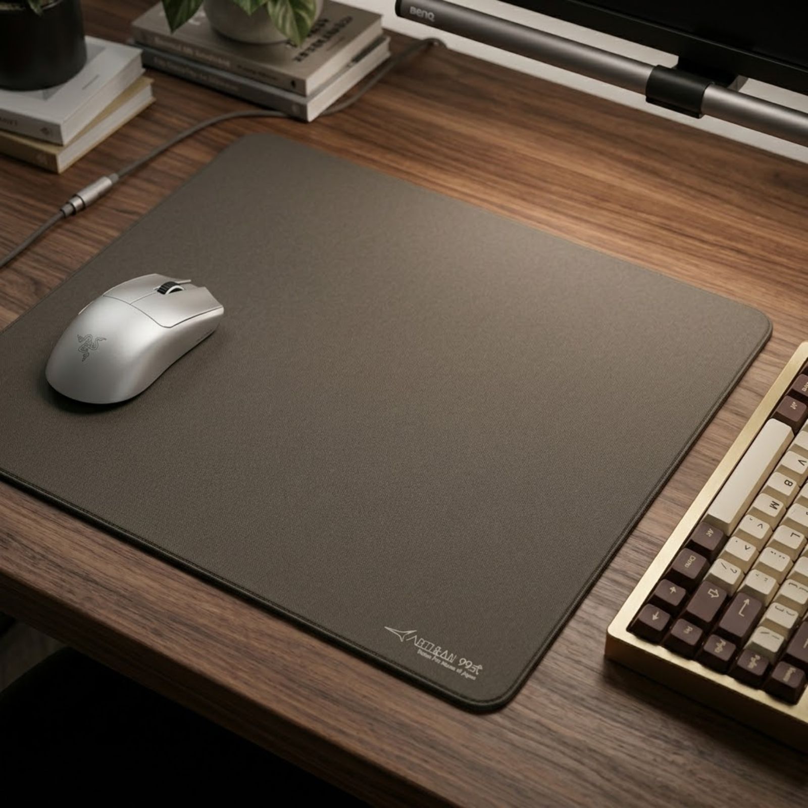 A gray ARTISAN NINJA FX Type-99 MID XL gaming mouse pad placed on a gaming desk with a lightweight gaming mouse positioned near the center of the surface.