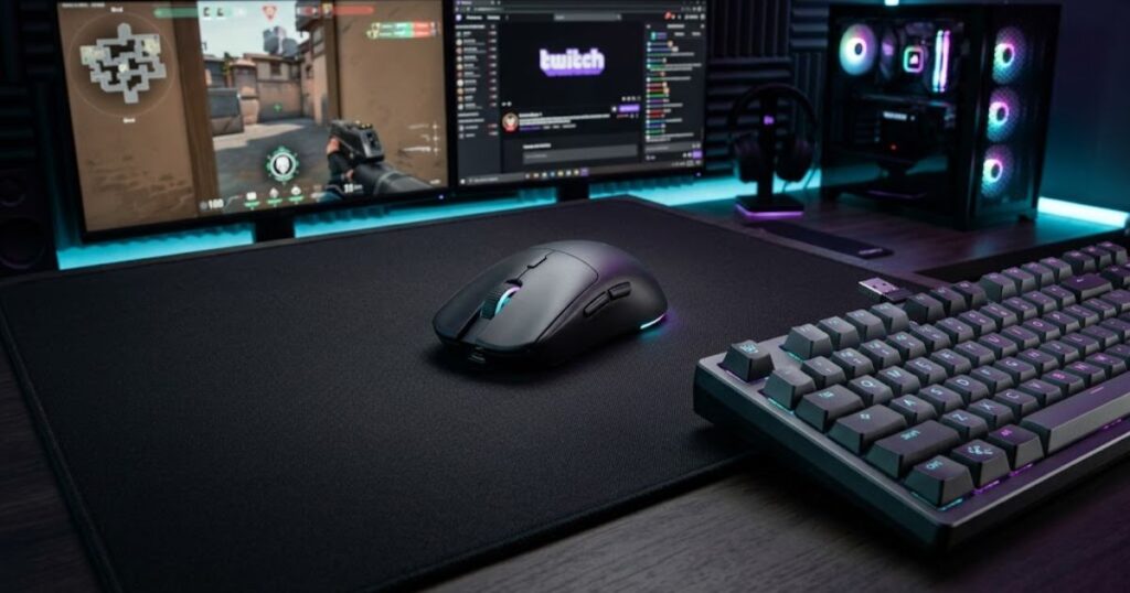 A lightweight wireless gaming mouse positioned on a cloth mouse pad beside a gaming keyboard.