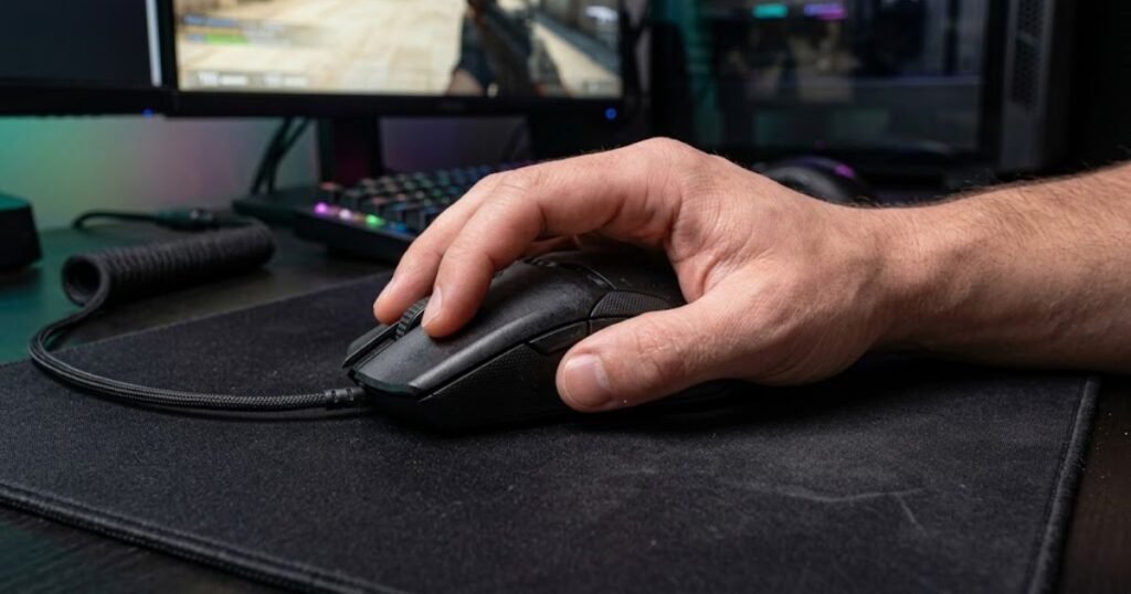 Hand using a palm grip on a large heavy gaming mouse placed on a cloth mouse pad