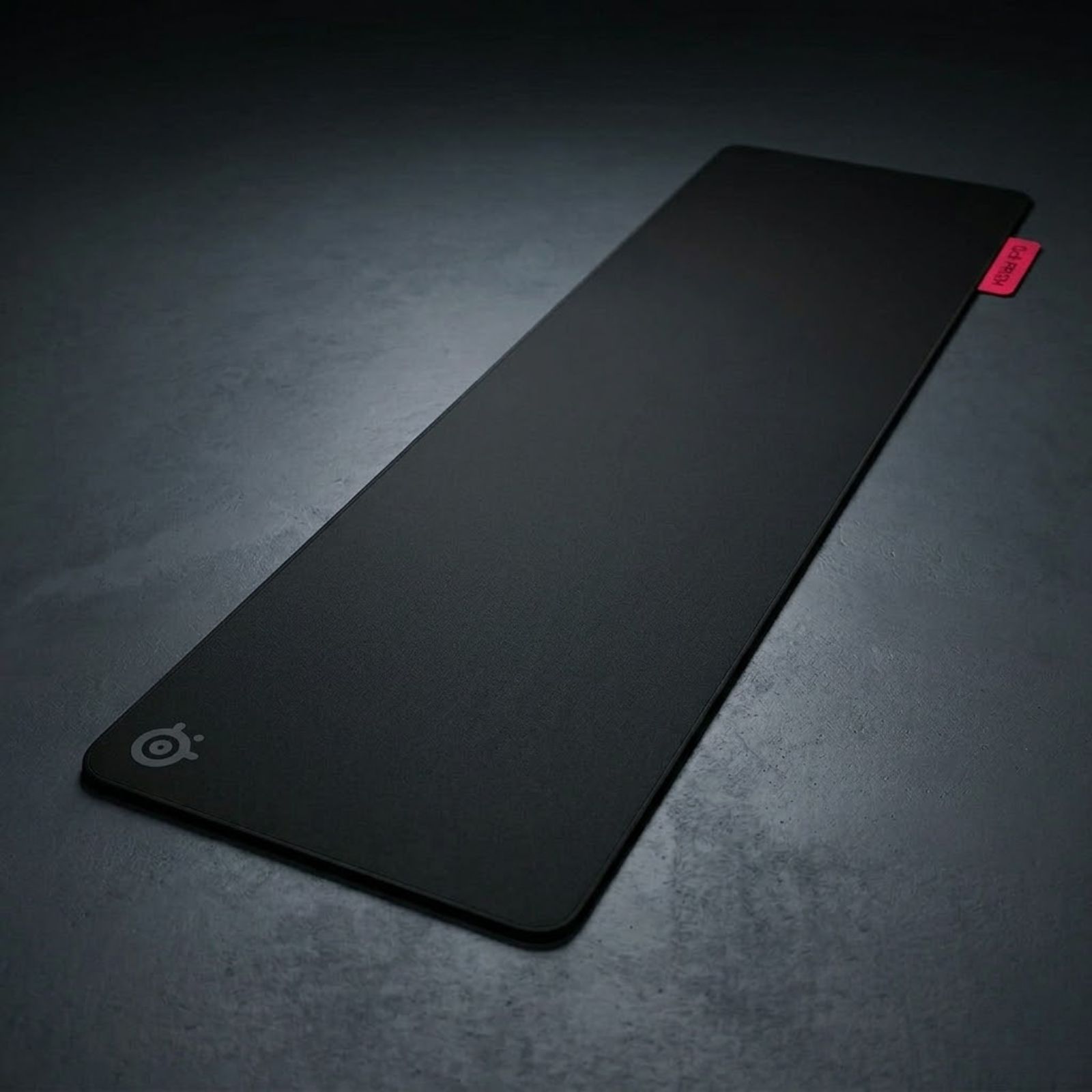 A SteelSeries QcK Performance Speed XL gaming mouse pad covering a gaming desk with a lightweight gaming mouse and keyboard placed on top.