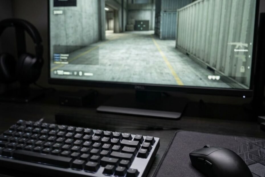 Gaming keyboard and mouse on a competitive FPS gaming desk with a monitor in the background