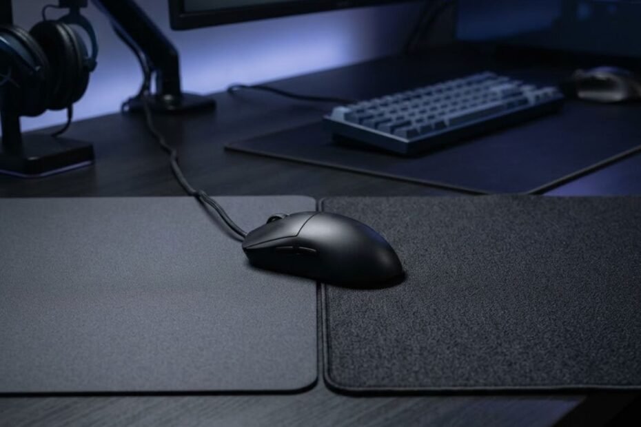 Gaming mouse positioned between speed and control mouse pad surfaces for Valorant aiming